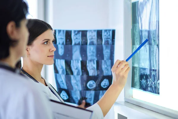 Two female doctors pointing at x-rays in a hospital — Stock Photo, Image