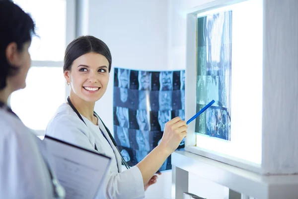 Due medici sorridenti che puntano i raggi X in una sala di consulenza ospedaliera — Foto Stock