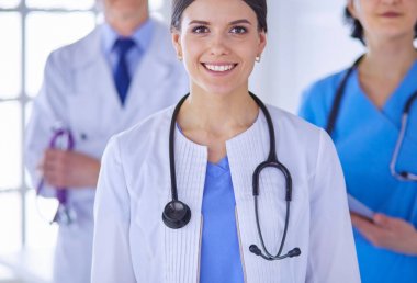 Bir grup doktor ve hemşire bir hastane odasında duruyor.