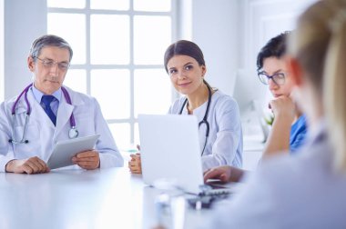 Doktorlar hastane konferans odasında birbirlerine danışıyorlar.