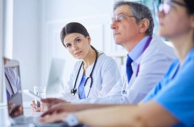 Doktorlar hastane konferans odasında birbirlerine danışıyorlar.