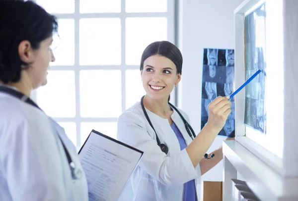 Due medici sorridenti che puntano i raggi X in una sala di consulenza ospedaliera — Foto Stock
