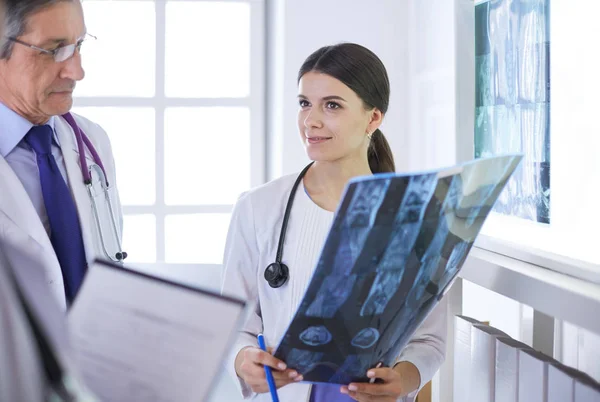 Lächelnde Ärzte diskutieren die Diagnose ihrer Patienten beim Röntgen im Krankenhaus — Stockfoto