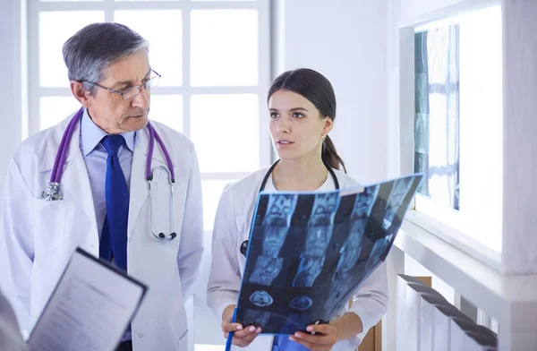 Orvosok csoportja, akik a röntgenfelvételeket ellenőrzik a kórházban — Stock Fotó