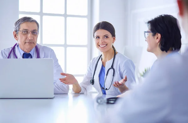 Seriöses Ärzteteam mit Laptop in einem hellen Beratungsraum — Stockfoto