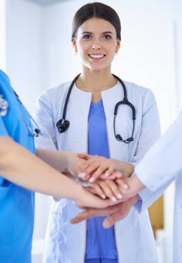 Bir grup doktor ellerini birleştiriyor.