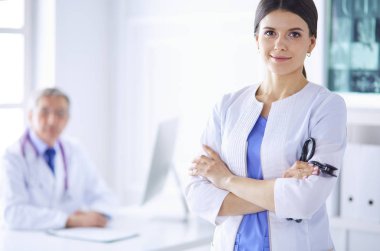 İki doktor hastanedeki konferans odasında, biri kameraya bakıyor.