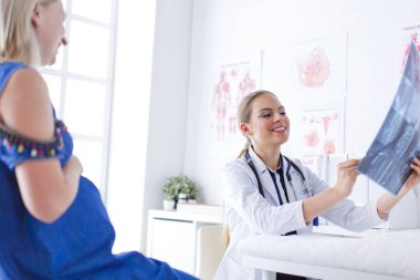 Genç ve çekici bayan doktor röntgen görüntülerine bakıyor.