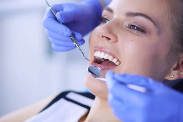 Mujer joven con la boca abierta examinando la inspección dental en el consultorio del dentista. — Foto de Stock