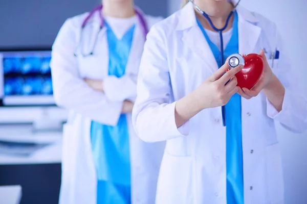 Abgeschnittene Aufnahme zweier junger Ärztinnen mit Stethoskop am Herzen. — Stockfoto