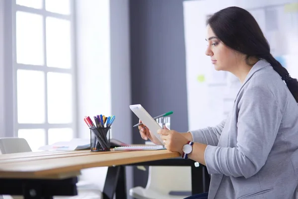 Muito jovem gerente do sexo feminino usando tablet digital moderno no escritório. — Fotografia de Stock