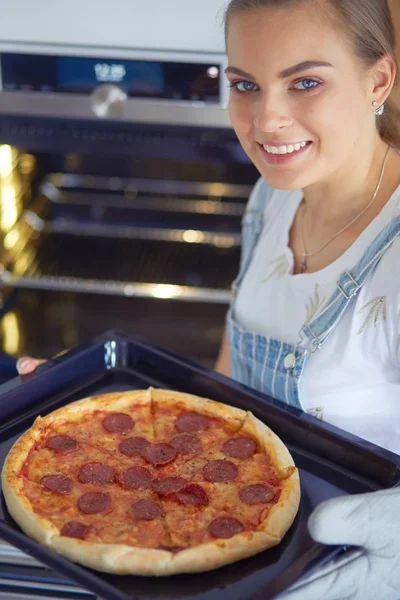 Happy young woman cooking pizza at home — Stock Photo, Image