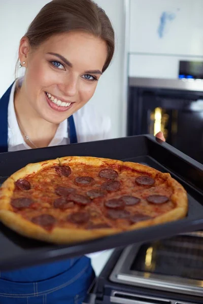 Happy young woman cooking pizza at home — Stock Photo, Image