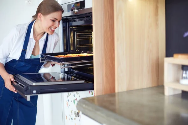 Feliz joven cocinando pizza en casa — Foto de Stock