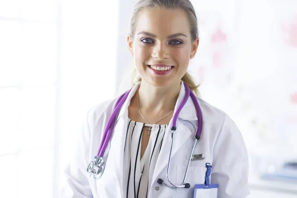 Улыбающаяся женщина-врач с медицинским стетоскопом в форме стоя — стоковое фото