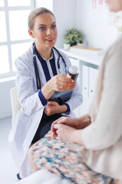 Doctor y paciente discutiendo algo mientras están sentados en la mesa. Concepto de medicina y salud — Foto de Stock