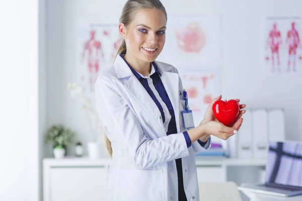 Un medico con stetoscopio che esamina il cuore rosso, isolato su sfondo bianco — Foto Stock