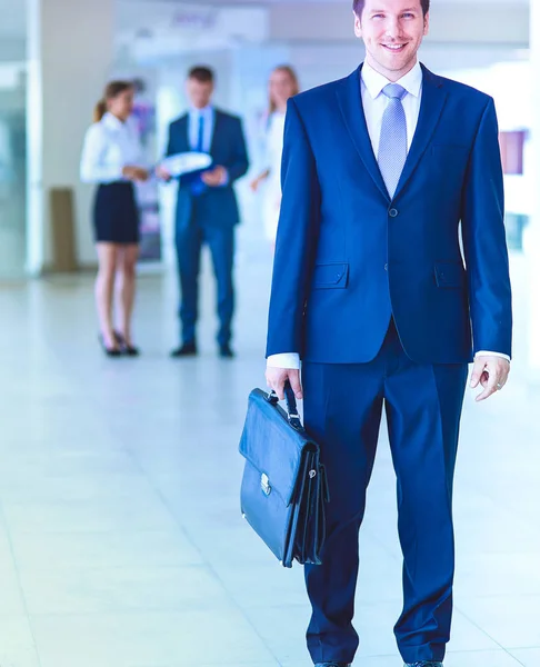 Porträtt av ung affärsman i tjänst med kollegor i bakgrunden. Porträtt av ung affärsman. — Stockfoto