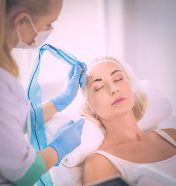 Kaşlar için kalıcı makyaj. Güzellik salonunda kalın kaşlı güzel bir kadın..