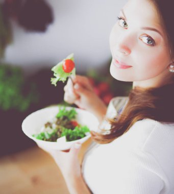 Salata yemek ve karışık salata tutan genç kadın