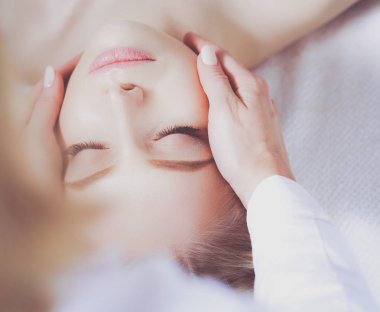 Masaj masasında uzanmış gözleri kapalı rahatlayan genç bir kadın. - Kadın. Spa salonu