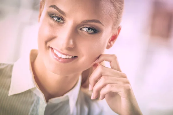 Attractive businesswoman sitting on a desk with laptop in the office — Stock Photo, Image