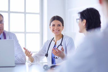 Parlak bir ofiste çalışan ciddi bir tıbbi ekip.