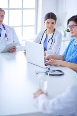 Ciddi bir tıbbi ekip hastaları parlak bir ofiste tartışıyor.