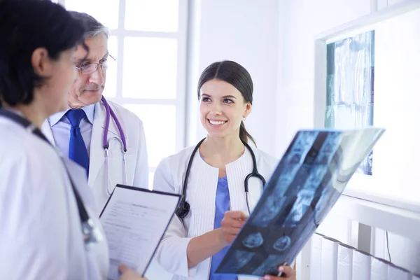 Médecins souriants discutant du diagnostic des patients regardant les rayons X dans un hôpital — Photo