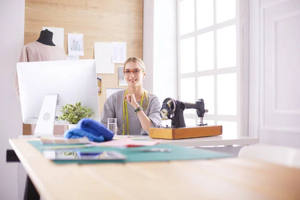 Schönes junges Mädchen in einer Fabrik mit einer Nähmaschine am Tisch — Stockfoto