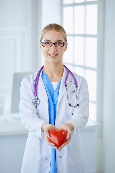 Läkare med stetoskop håller hjärtat, isolerad på vit bakgrund — Stockfoto