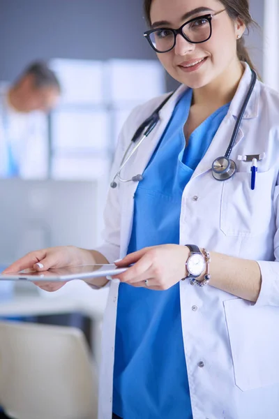 Female doctor using tablet computer in hospital lobby — Stock Photo, Image