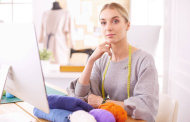 Moda tasarımcısı stüdyoda tablet bilgisayar kullanıyor.