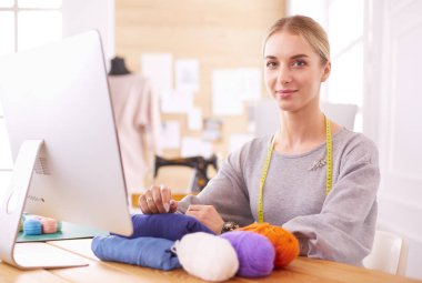 Moda tasarımcısı stüdyoda tablet bilgisayar kullanıyor.