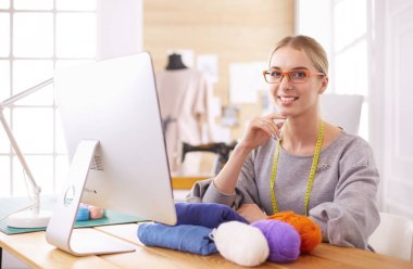 Moda tasarımcısı stüdyoda tablet bilgisayar kullanıyor.