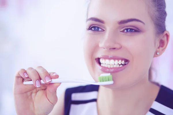 Joven chica bonita manteniendo la higiene bucal con cepillo de dientes . — Foto de Stock