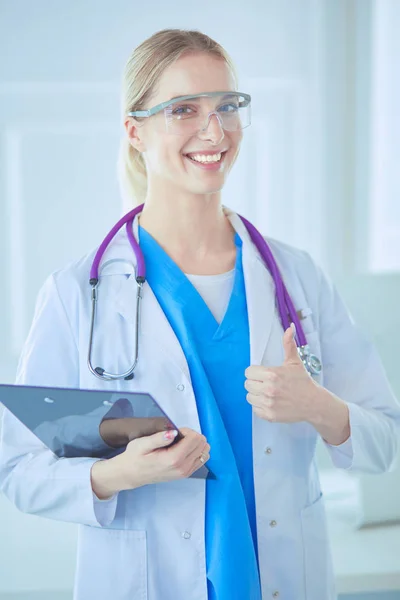 Smiling doctor woman in blue uniform with stethoscope showing okay sign hand gesture isolated on white background — Stock Photo, Image