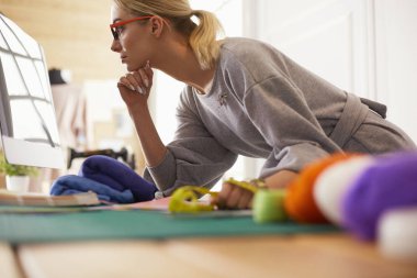 Moda Tasarımcısı dizüstü bilgisayarda çalışan atölye