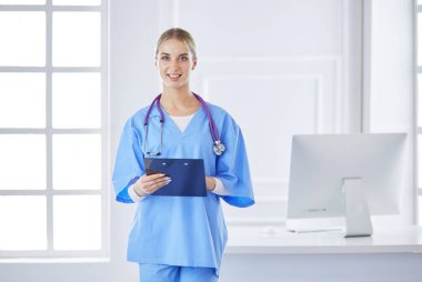 Üniformalı bir dosyayla gülümseyen kadın doktor