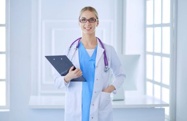 Üniformalı bir dosyayla gülümseyen kadın doktor