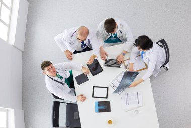 Tıbbi ekip masaya oturuyor ve tartışıyor.