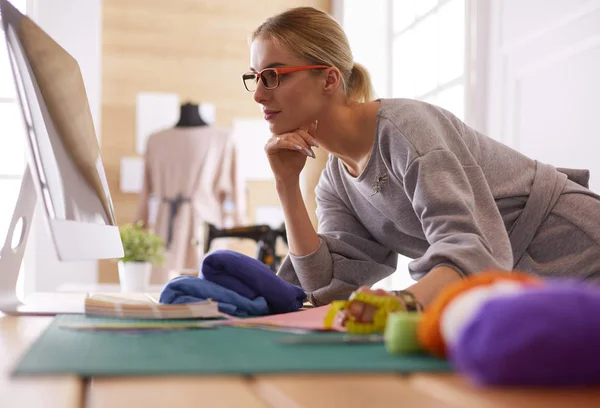 Jonge aantrekkelijke vrouwen mode ontwerpers leunend op kantoor, werken met een laptop — Stockfoto