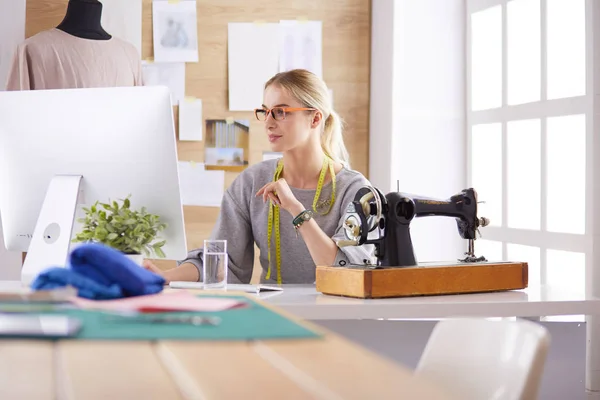 Mooi jong meisje in een fabriek met een naaimachine aan de tafel — Stockfoto