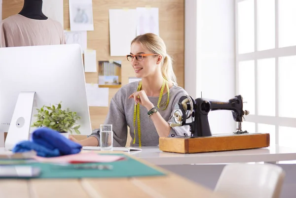 Mooi jong meisje in een fabriek met een naaimachine aan de tafel — Stockfoto