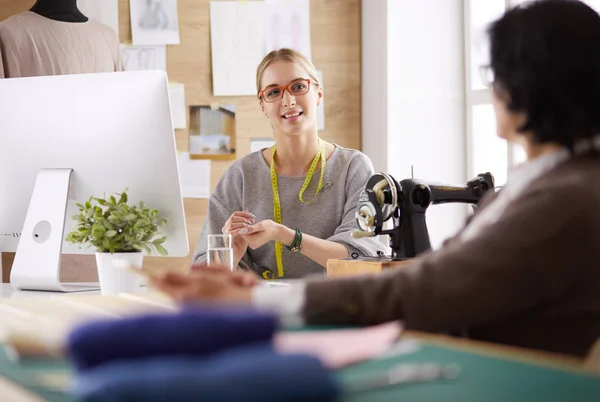 Female dressmaker is communicating with the potential client about custom-made dress in the sewing workshop — Stock Photo, Image