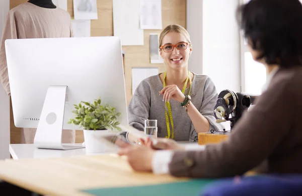 Female dressmaker is communicating with the potential client about custom-made dress in the sewing workshop — Stock Photo, Image