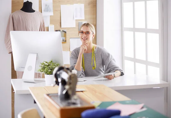 Belle jeune fille dans une usine avec une machine à coudre à la table — Photo