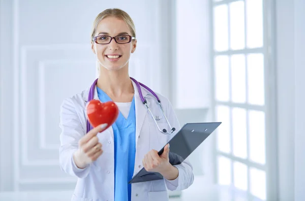 Ženský lékař se stetoskopem držící srdce — Stock fotografie