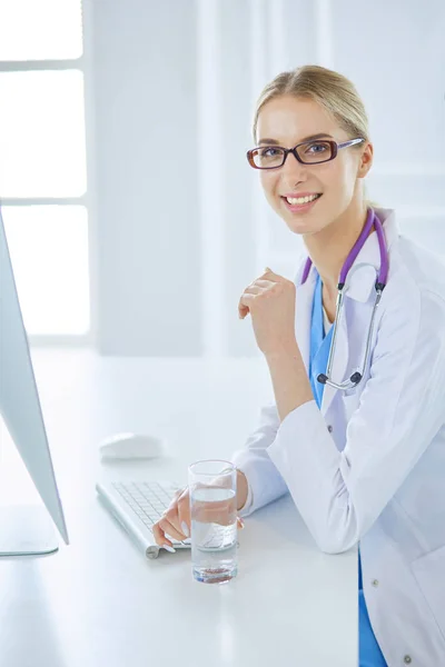 Portrét mladé doktorky sedící za stolem v nemocnici — Stock fotografie
