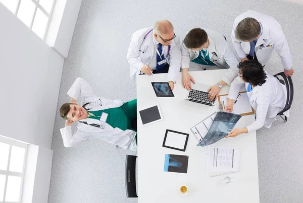 Equipo médico sentado y discutiendo en la mesa, vista superior —  Fotos de Stock